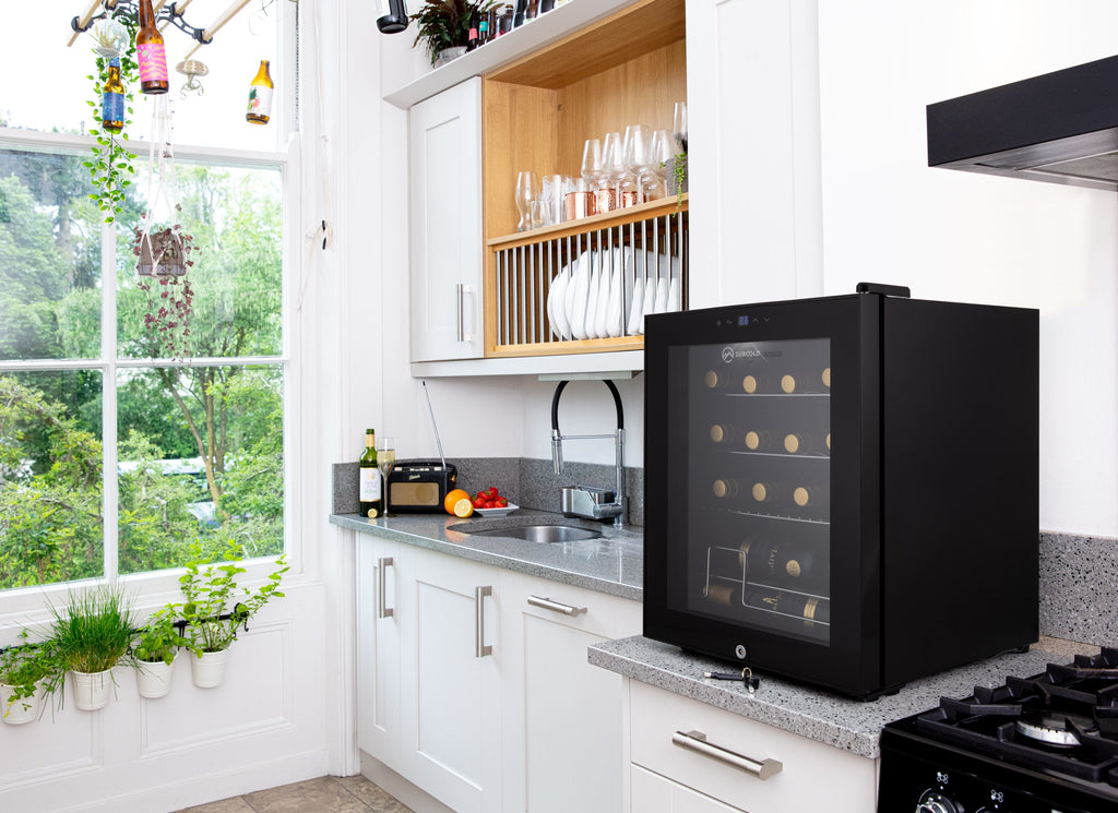 Black wine cooler on kitchen countertop with glass door and warm LED interior