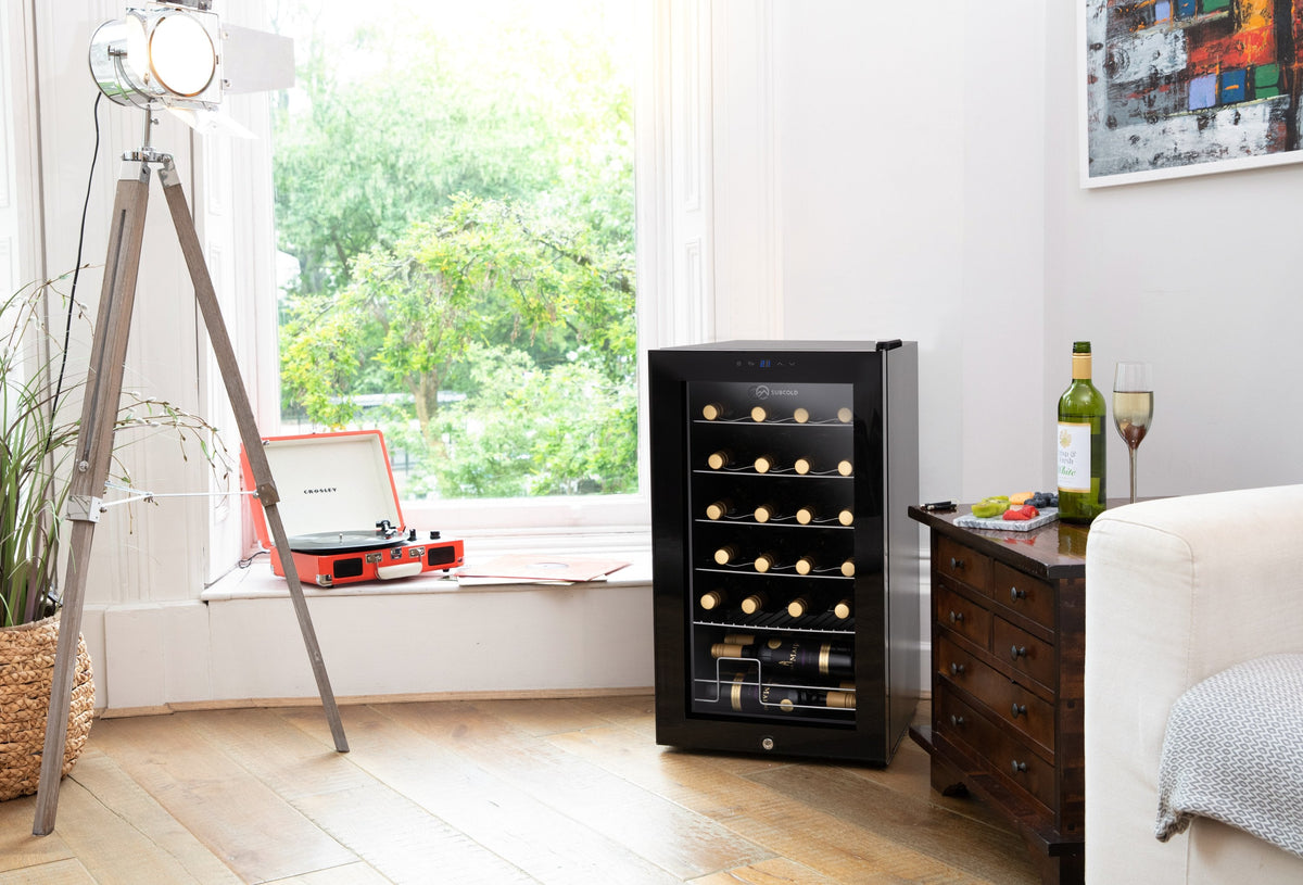 Freestanding wine cooler with glass door, shown in a room with bottles