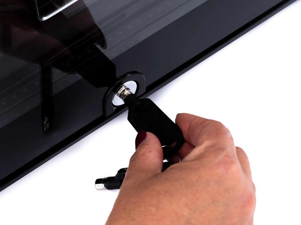 Wine cooler door lock with a key held near the glass door