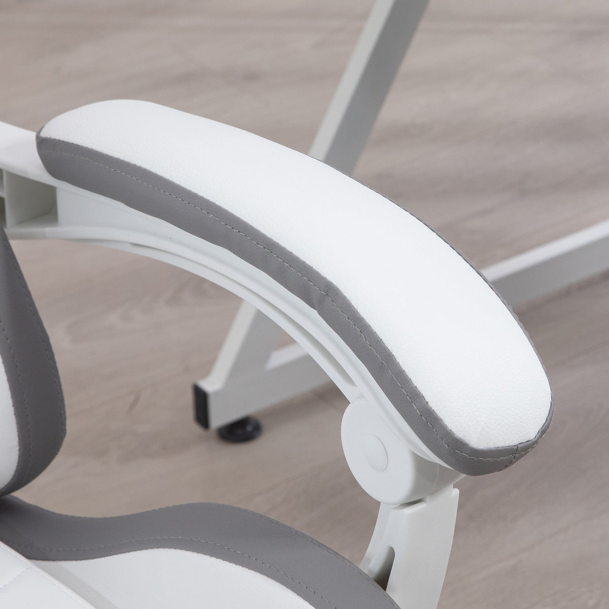 Close-up of white and gray padded armrest on a swivel gaming chair